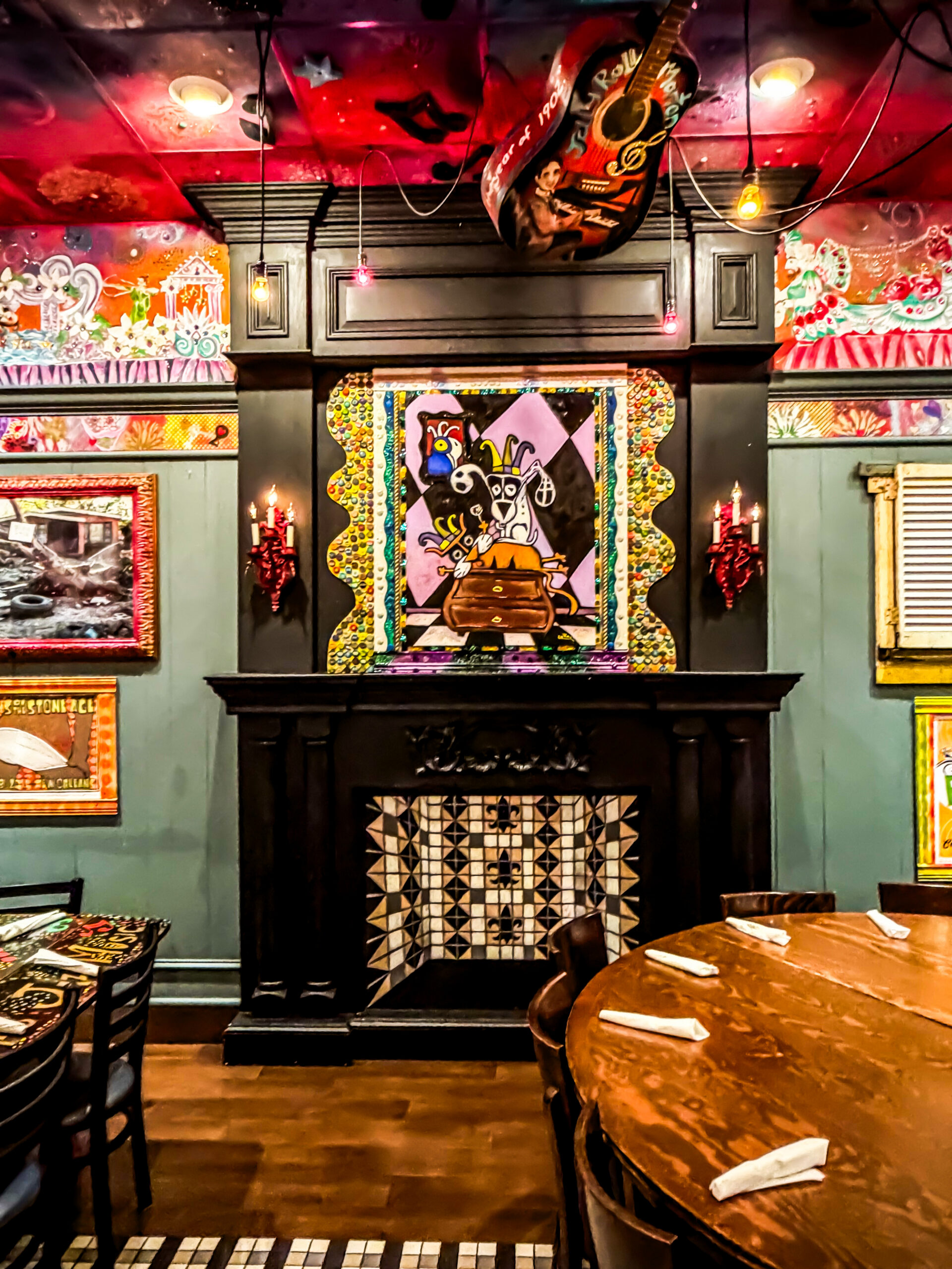 Fireplace and folk-art painting in the Napoleon Room at Tibby's Winter Park, below a hand-painted ceiling