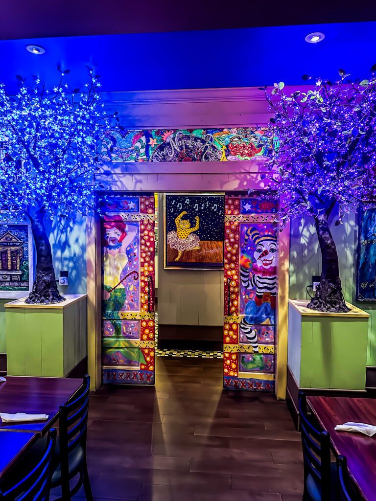 The hand-painted entrance to the Napoleon Room at Tibby’s Brandon, flanked by lit blossom trees